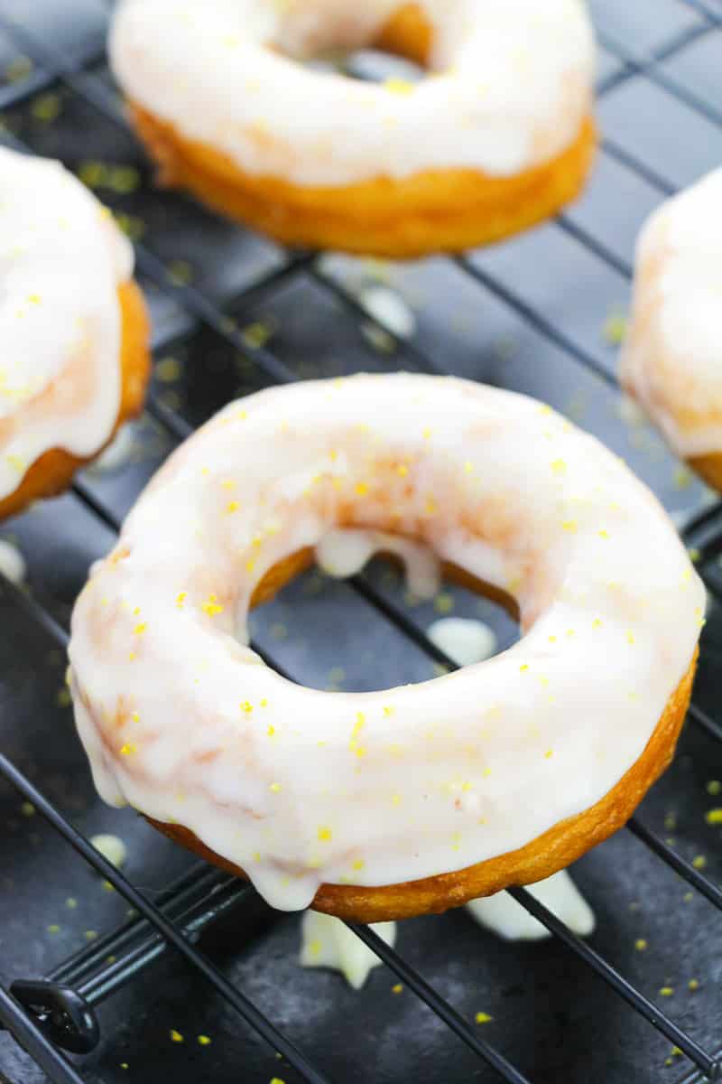 glazed biscuit donuts dripping on cooling rack